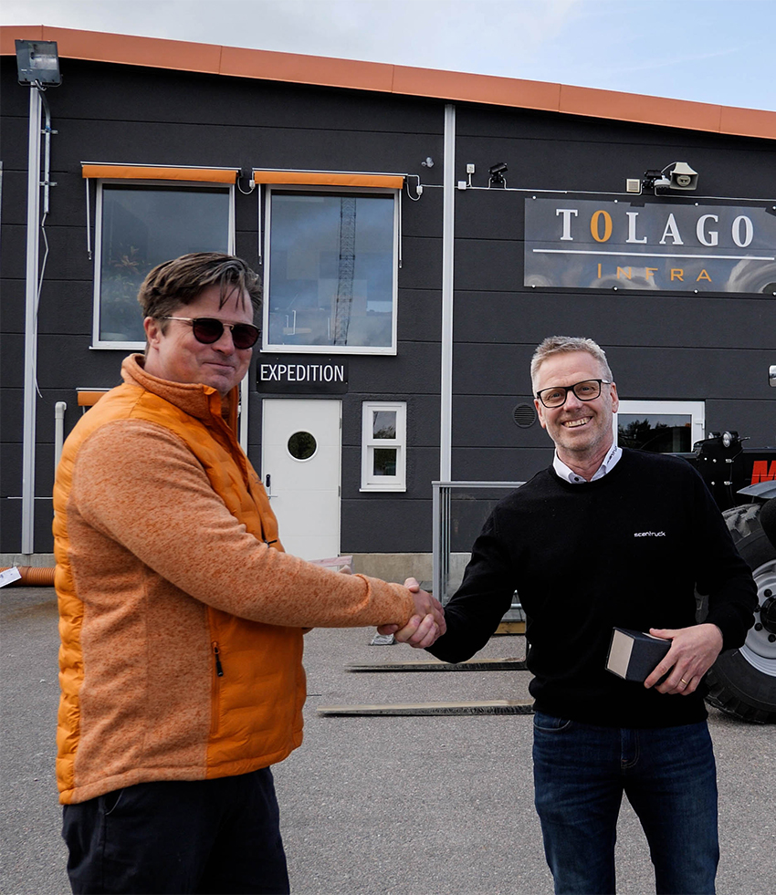 Tony Winder tar emot en gåva som följer med den unika maskinen som såldes av Lasse Lans på Scantruck AB. Maskinen har nr 23 av totalt 133 tillverkade och är den enda som hamnade i Sverige.